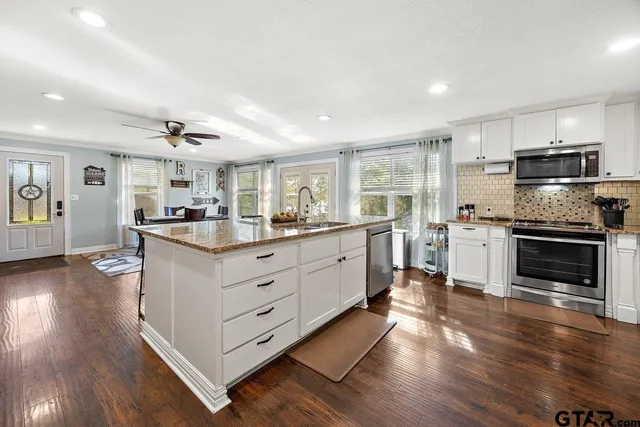a kitchen with granite countertop a stove top oven and cabinets