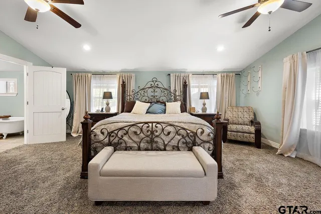 a bedroom with a large bed and a chandelier