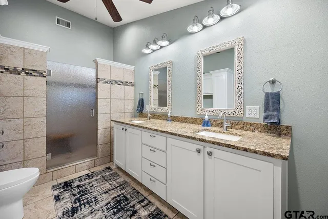 a bathroom with a double vanity sink mirror and toilet