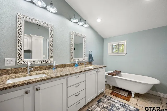 a spacious bathroom with a granite countertop sink and a mirror