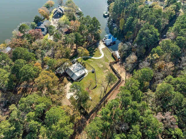 an aerial view of a house with a garden and lake view