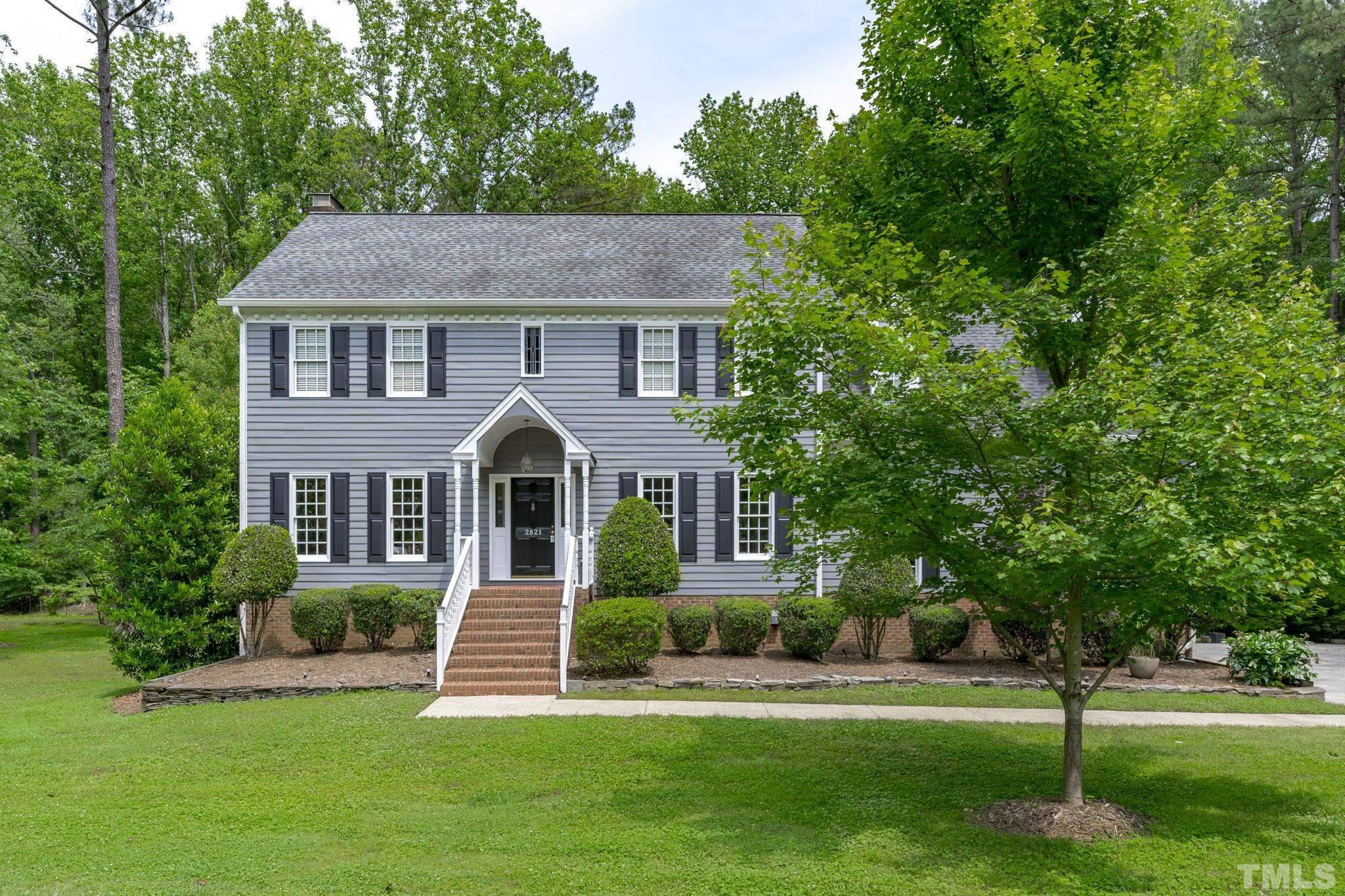 a front view of a house with a yard and trees