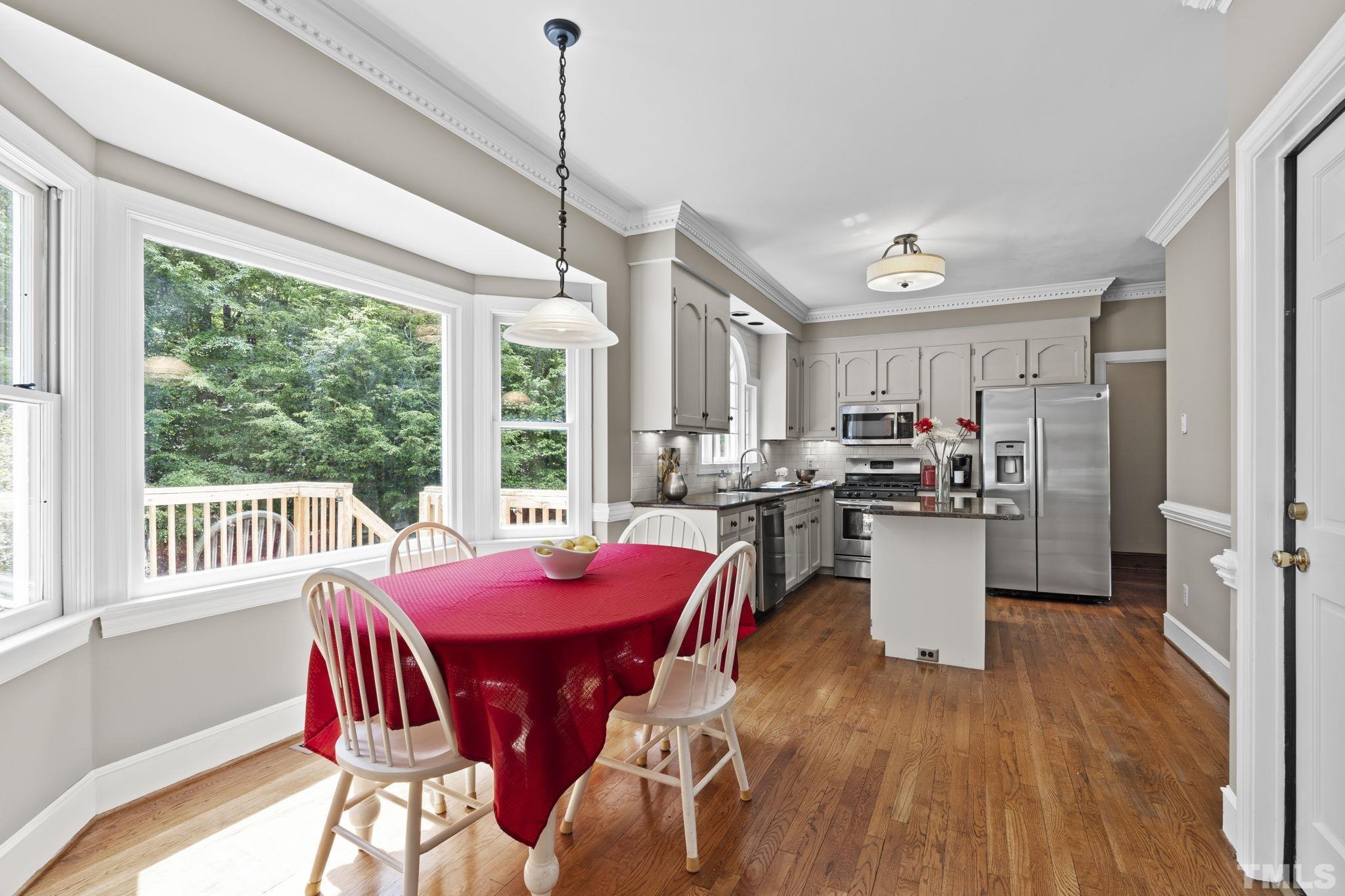 2821 Patrie Place Raleigh, NC 27613 - Photo 22 of 62 a view of a dining room and livingroom with furniture wooden floor a chandelier