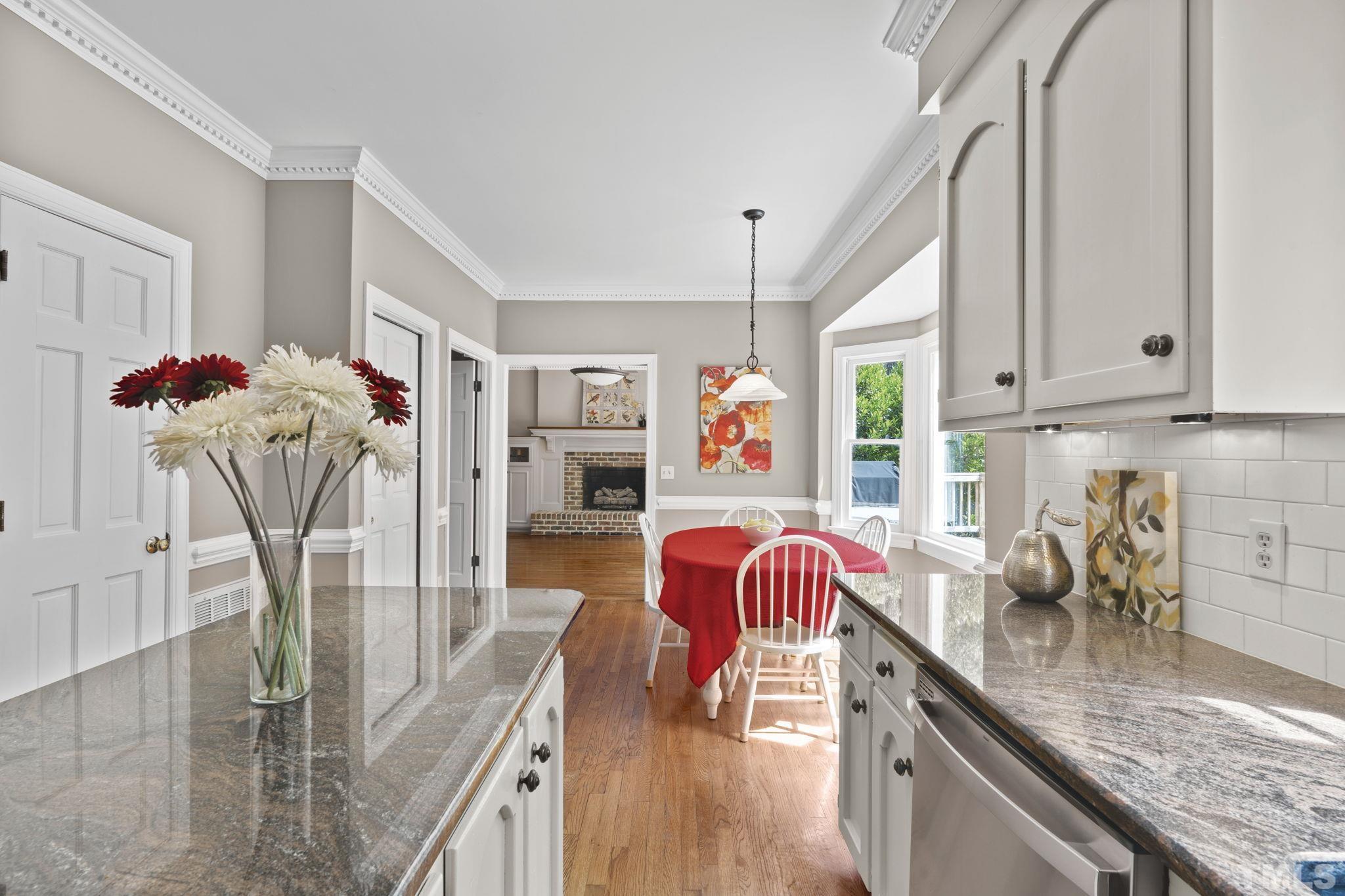 2821 Patrie Place Raleigh, NC 27613 - Photo 23 of 62 a kitchen with stainless steel appliances granite countertop a stove top oven a sink dishwasher and cabinets with wooden floor