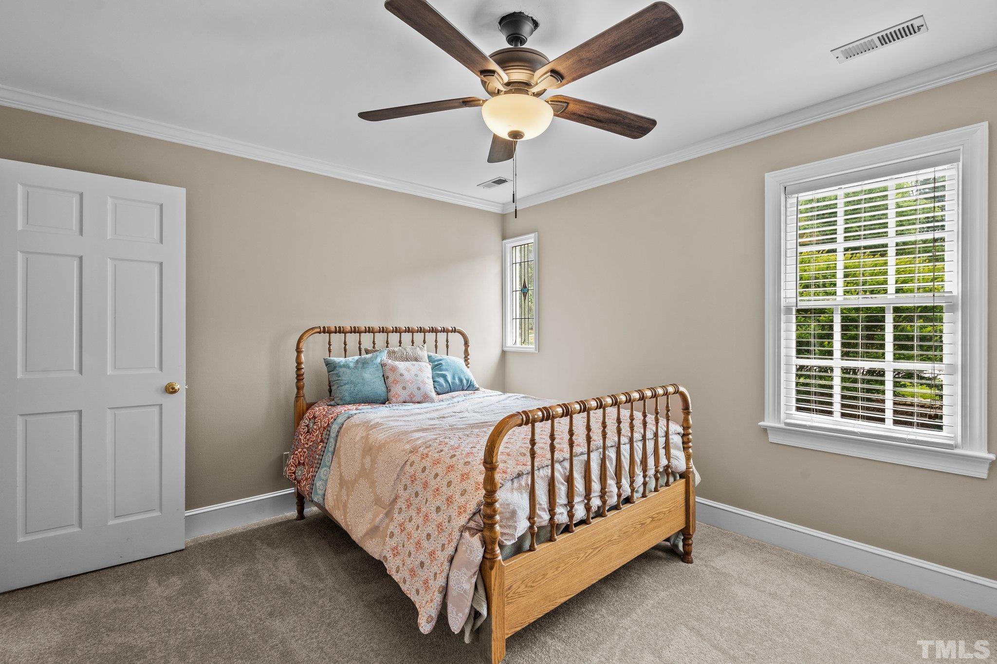 2821 Patrie Place Raleigh, NC 27613 - Photo 34 of 62 a bed sitting in a bedroom next to a window and a chandelier