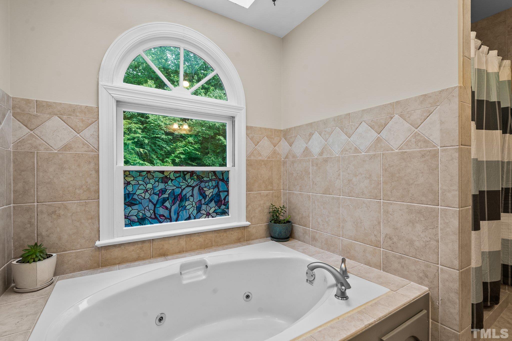 2821 Patrie Place Raleigh, NC 27613 - Photo 38 of 62 a bathroom with a tub a window and a shower
