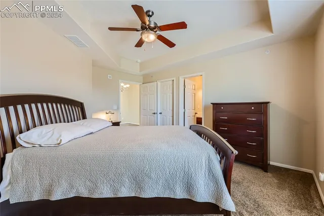 a bedroom with a bed and a ceiling fan