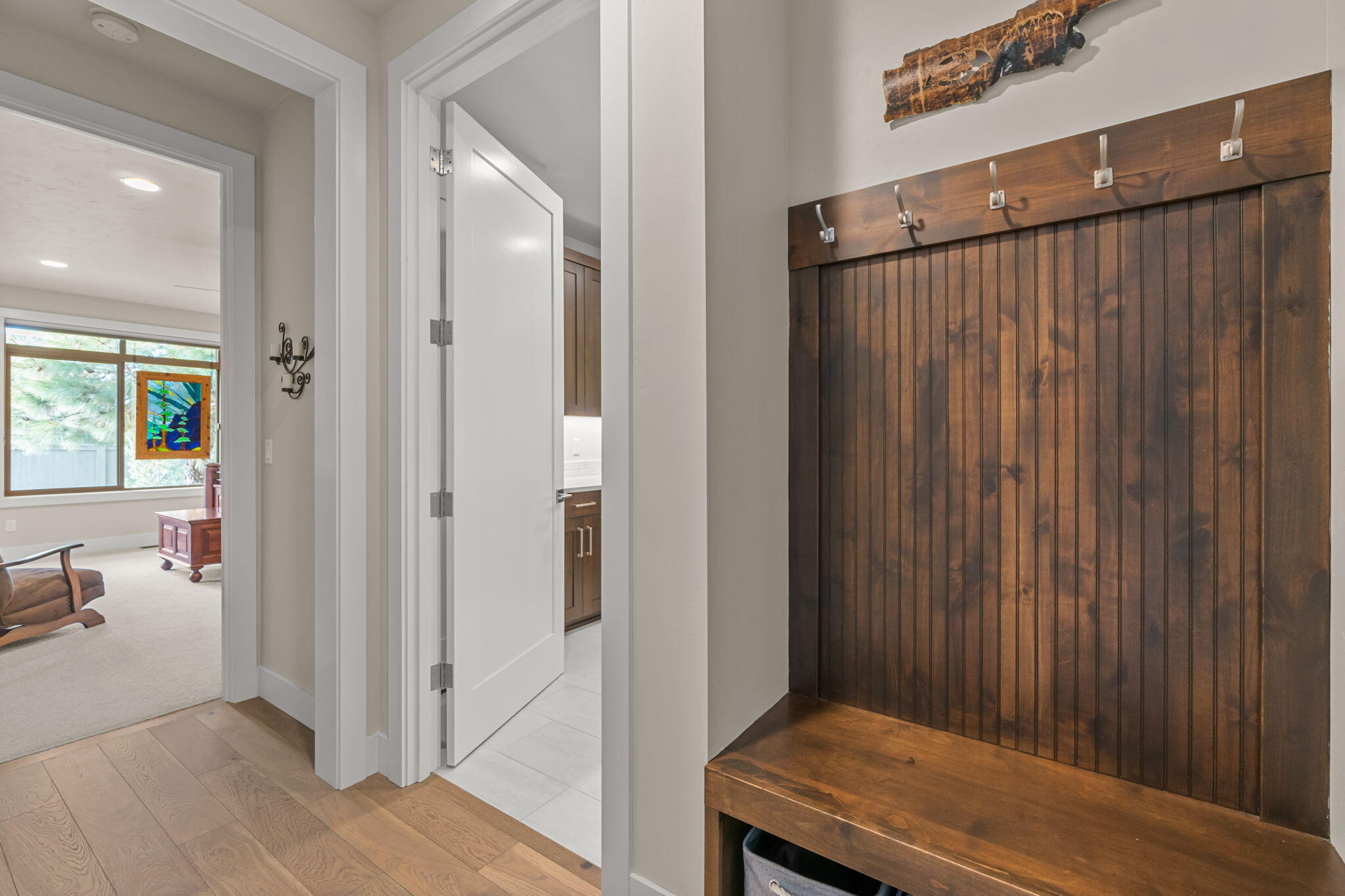 60861 Southwest Headwaters Loop Bend, OR 97702 - Photo 22 of 45 Hall off the garage with a built in bench and coat rack. The next door if the laundry room and the primary suite is at the opposite end.