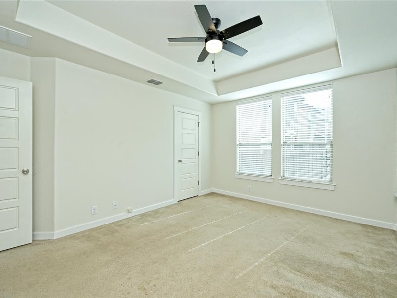 2101 Rivers Edge Way, Unit 29 Austin, TX 78741 - Photo 18 of 38 Main floor primary with walk in closet and en-suite