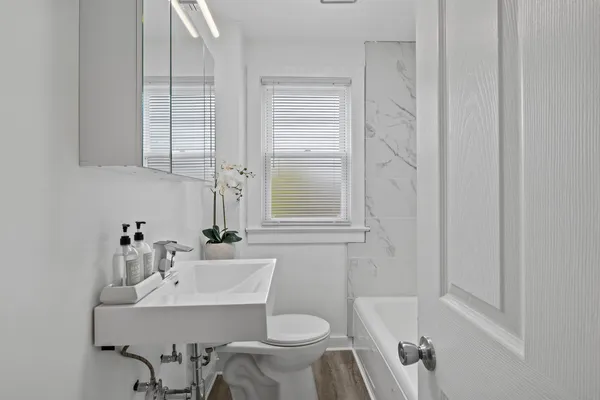 a bathroom with a sink toilet and a mirror
