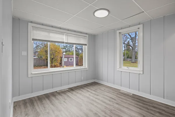 an empty room with wooden floor and windows