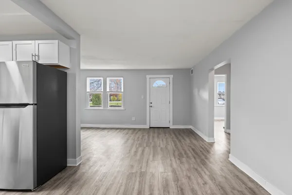 a view of an empty room with a window and wooden floor