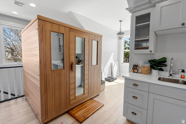 2917 Old Farm Road Washington, UT 84780 - Photo 78 of 105 Interior space featuring a relaxing sauna, light wood-style flooring, glass insert cabinets, hanging light fixtures, and gray cabinets