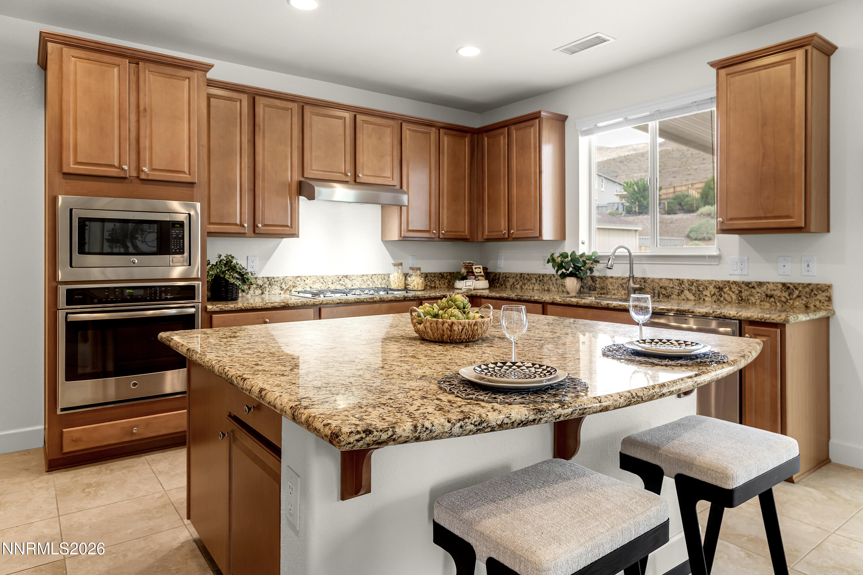 10150 Barrel Racer Drive Reno, NV 89521 - Photo 13 of 64 a kitchen with kitchen island granite countertop a stove a sink and a refrigerator
