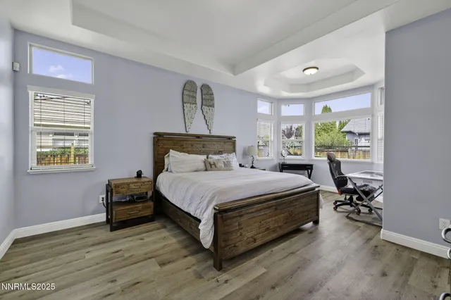 a bedroom with a bed and a flat tv screen on a dresser