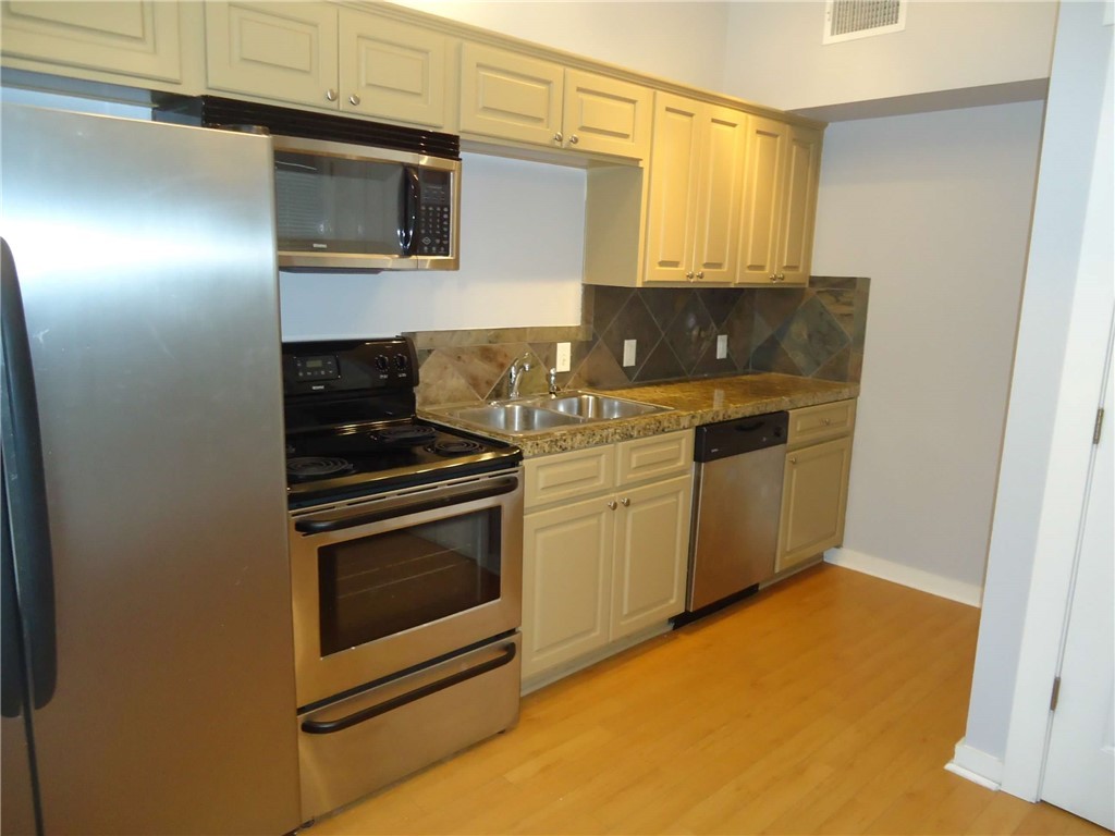 2106 Cullen Avenue, Unit 102 Austin, TX 78757 - Photo 3 of 11 a kitchen with stainless steel appliances granite countertop a stove and a microwave