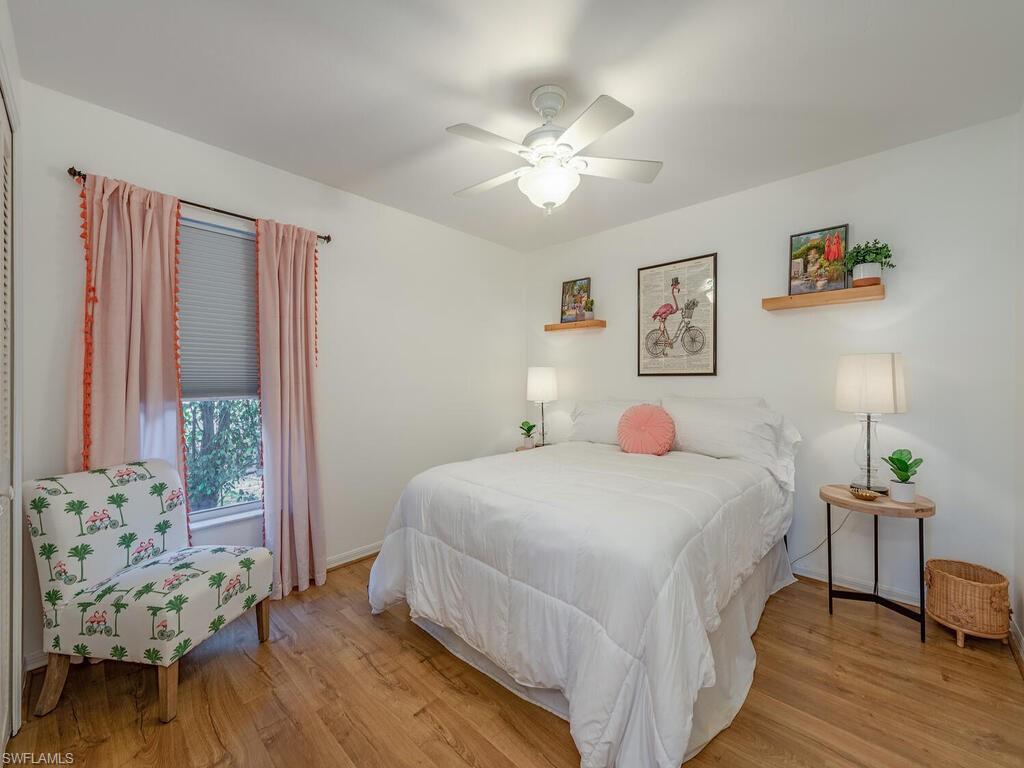 579 Raven Way Naples, FL 34110 - Photo 11 of 19 a bedroom with a bed and a chandelier