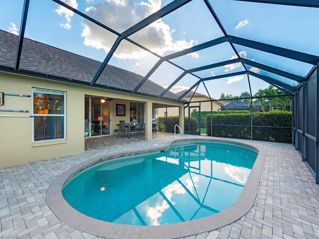 579 Raven Way Naples, FL 34110 - Photo 16 of 19 a view of a swimming pool with a patio