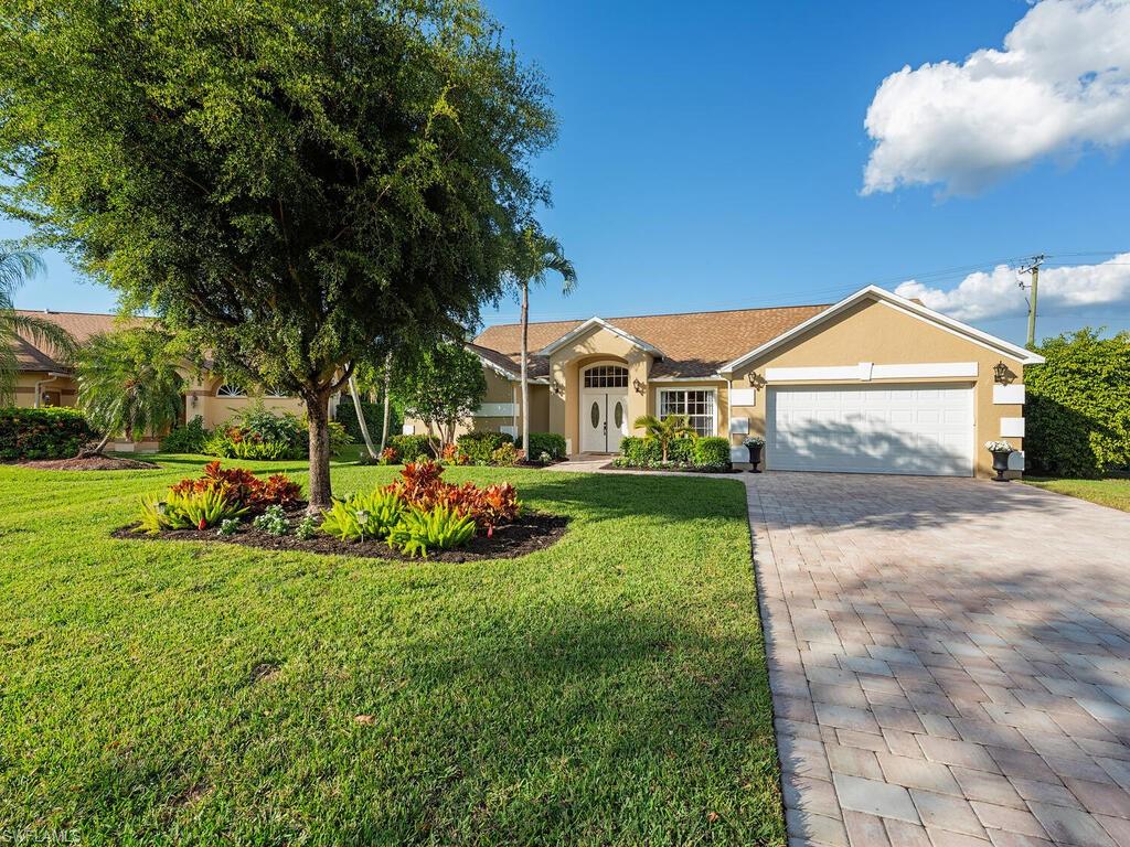 579 Raven Way Naples, FL 34110 - Photo 18 of 19 a view of a house with a big yard and potted plants