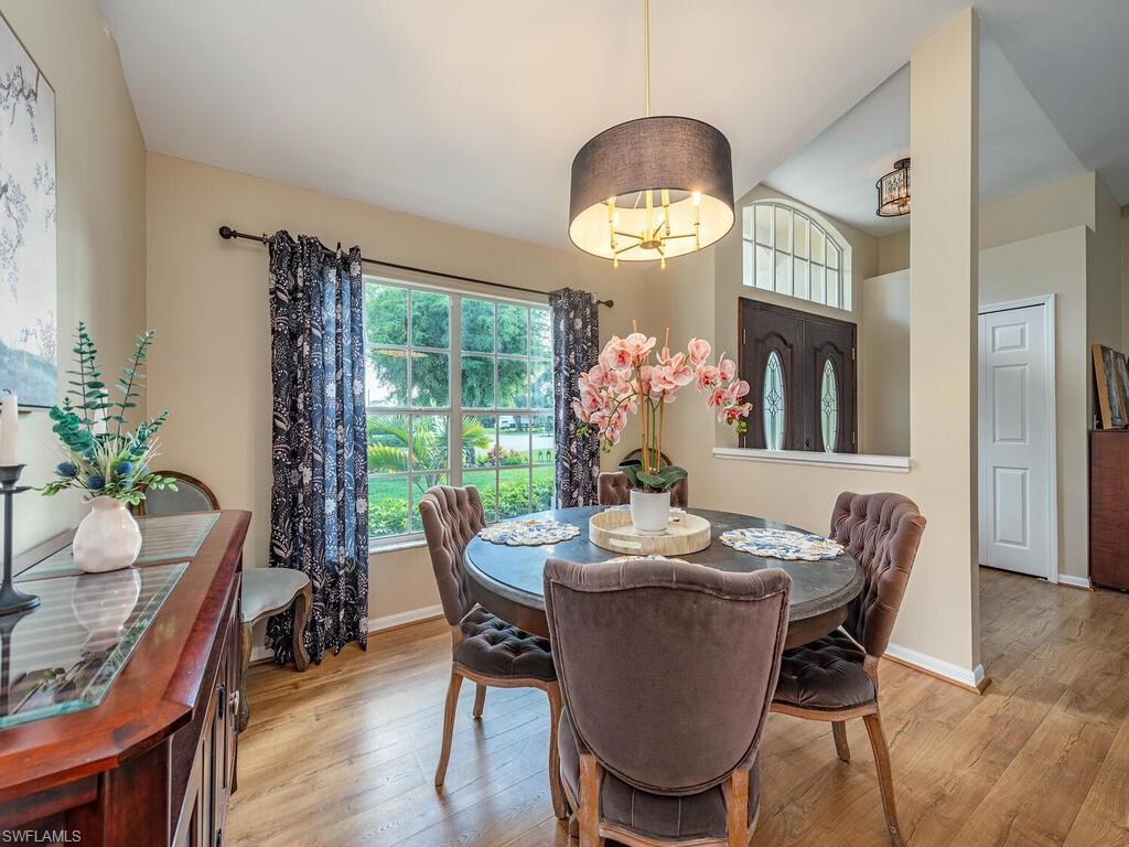 579 Raven Way Naples, FL 34110 - Photo 6 of 19 a dining room with furniture potted plants and wooden floor