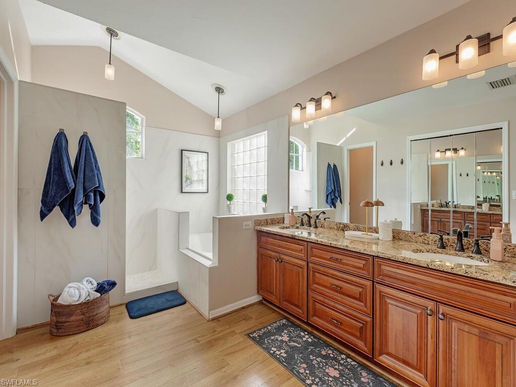 579 Raven Way Naples, FL 34110 - Photo 10 of 19 a spacious bathroom with a double vanity sink and a mirror