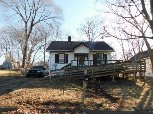 a front view of a house with yard covered by trees