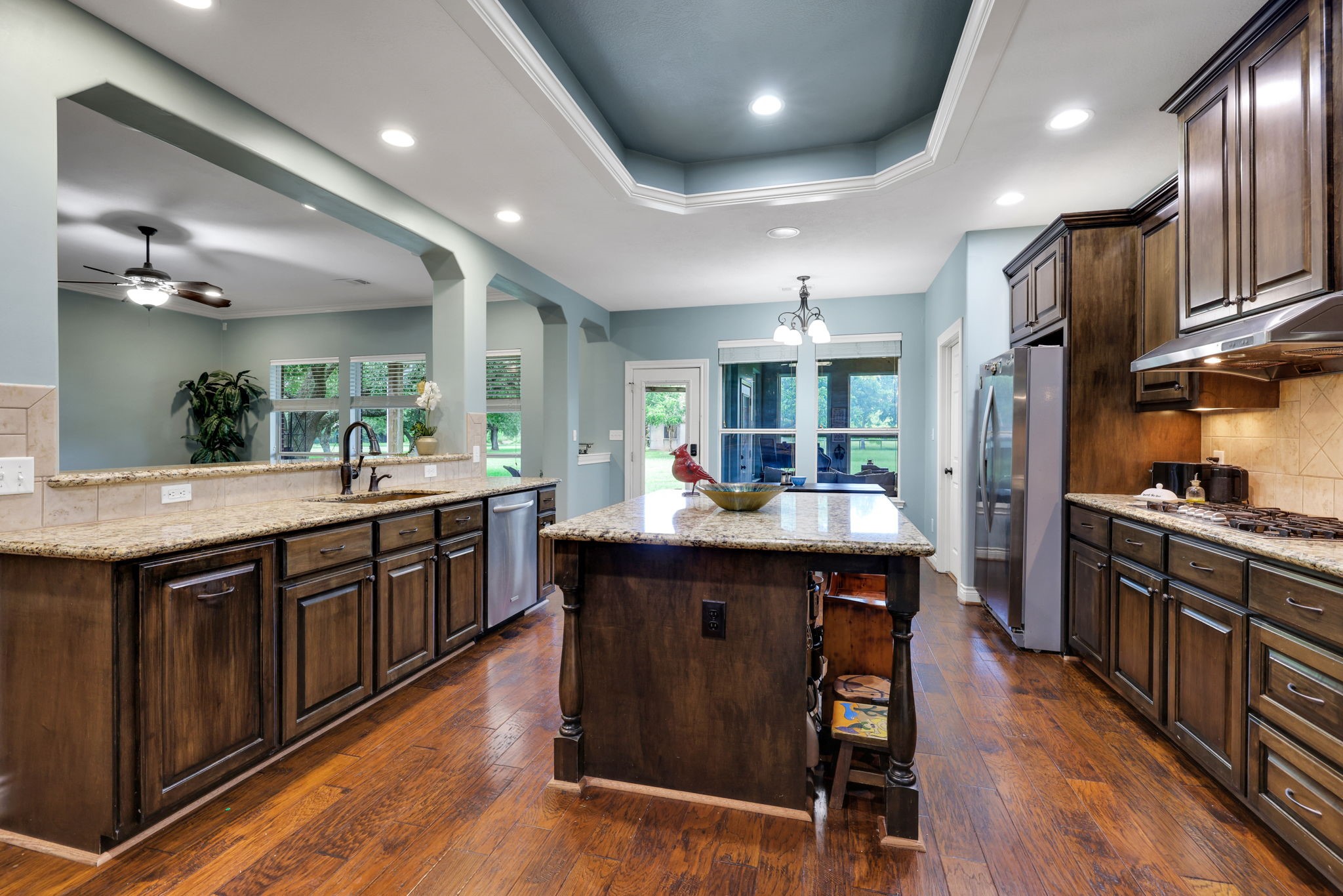 19407 Pine Tree Lane Waller, TX 77484 - Photo 17 of 39 a kitchen with stainless steel appliances granite countertop wooden floors and wooden cabinets