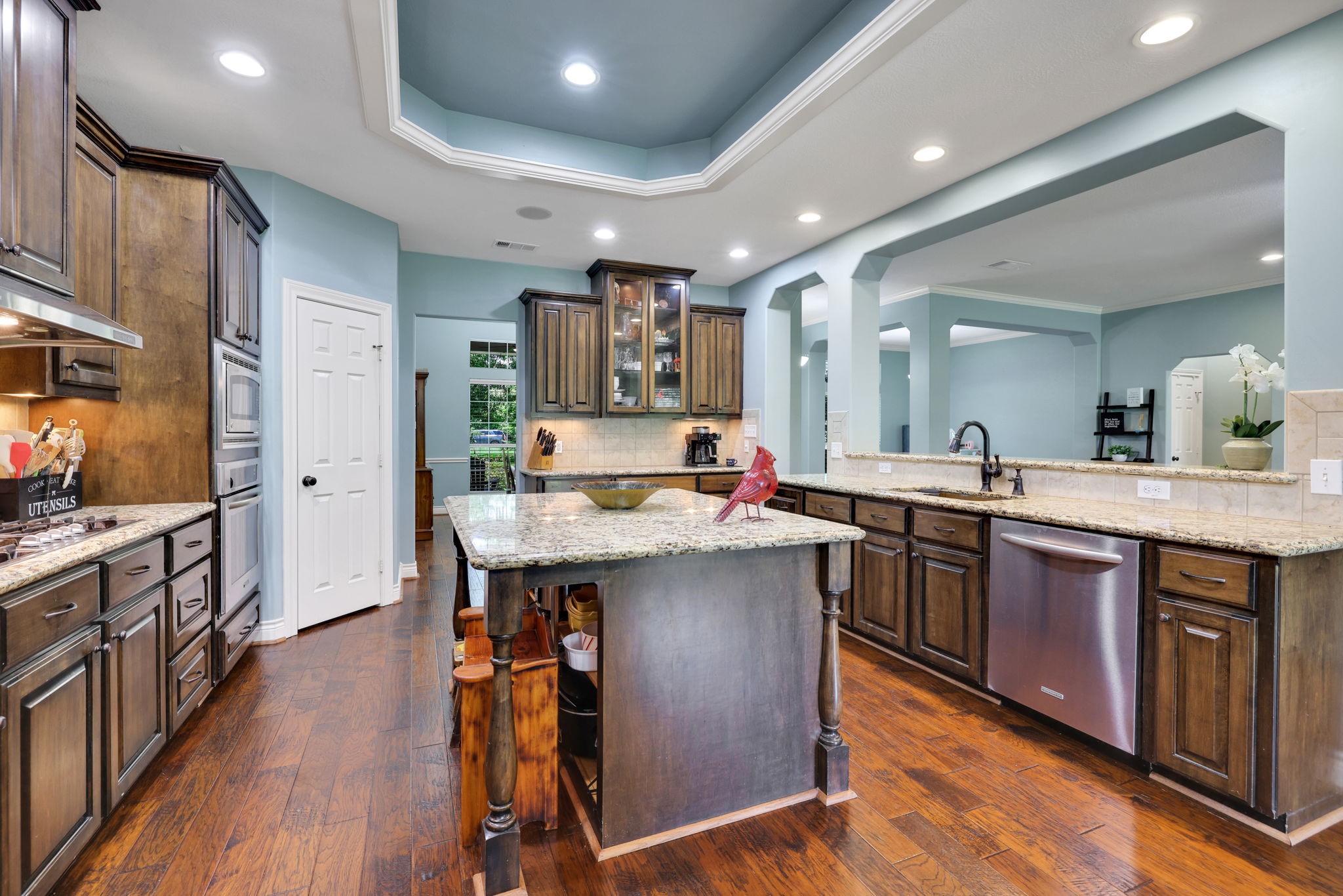 19407 Pine Tree Lane Waller, TX 77484 - Photo 18 of 39 a kitchen with stainless steel appliances granite countertop a sink a stove and a wooden floors