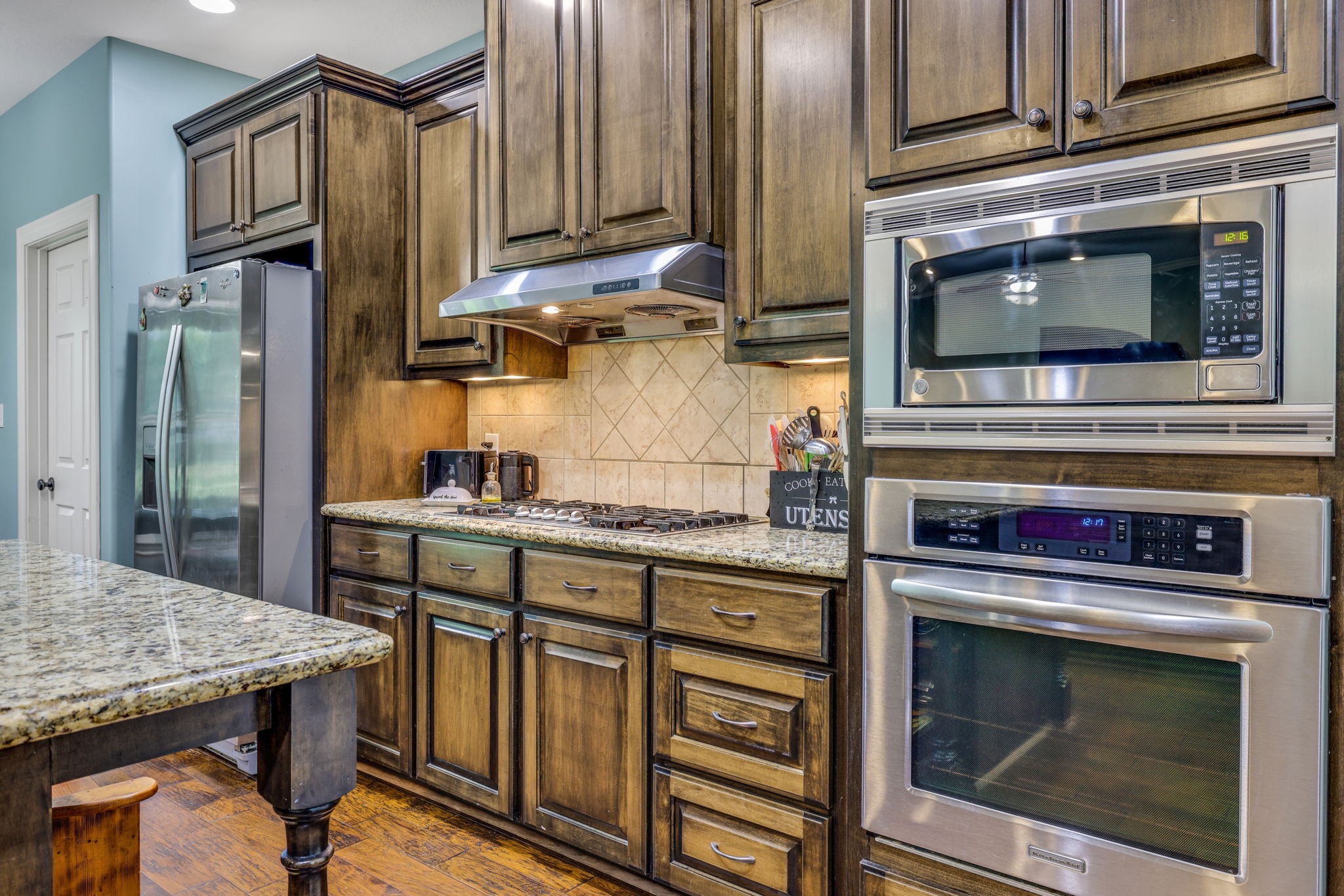 19407 Pine Tree Lane Waller, TX 77484 - Photo 19 of 39 a kitchen with stainless steel appliances granite countertop a stove microwave and refrigerator