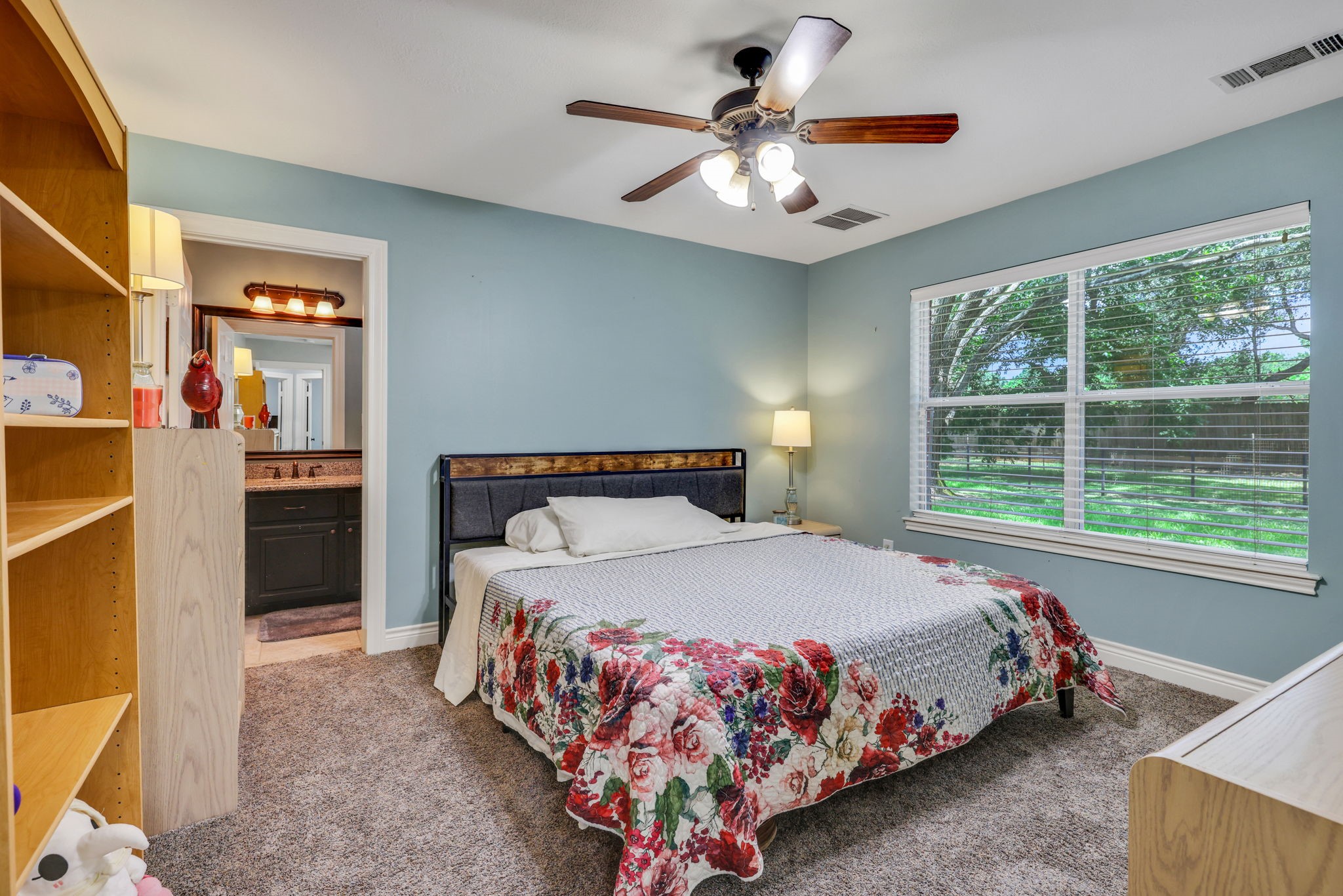 19407 Pine Tree Lane Waller, TX 77484 - Photo 30 of 39 a bedroom with a large bed and a chandelier