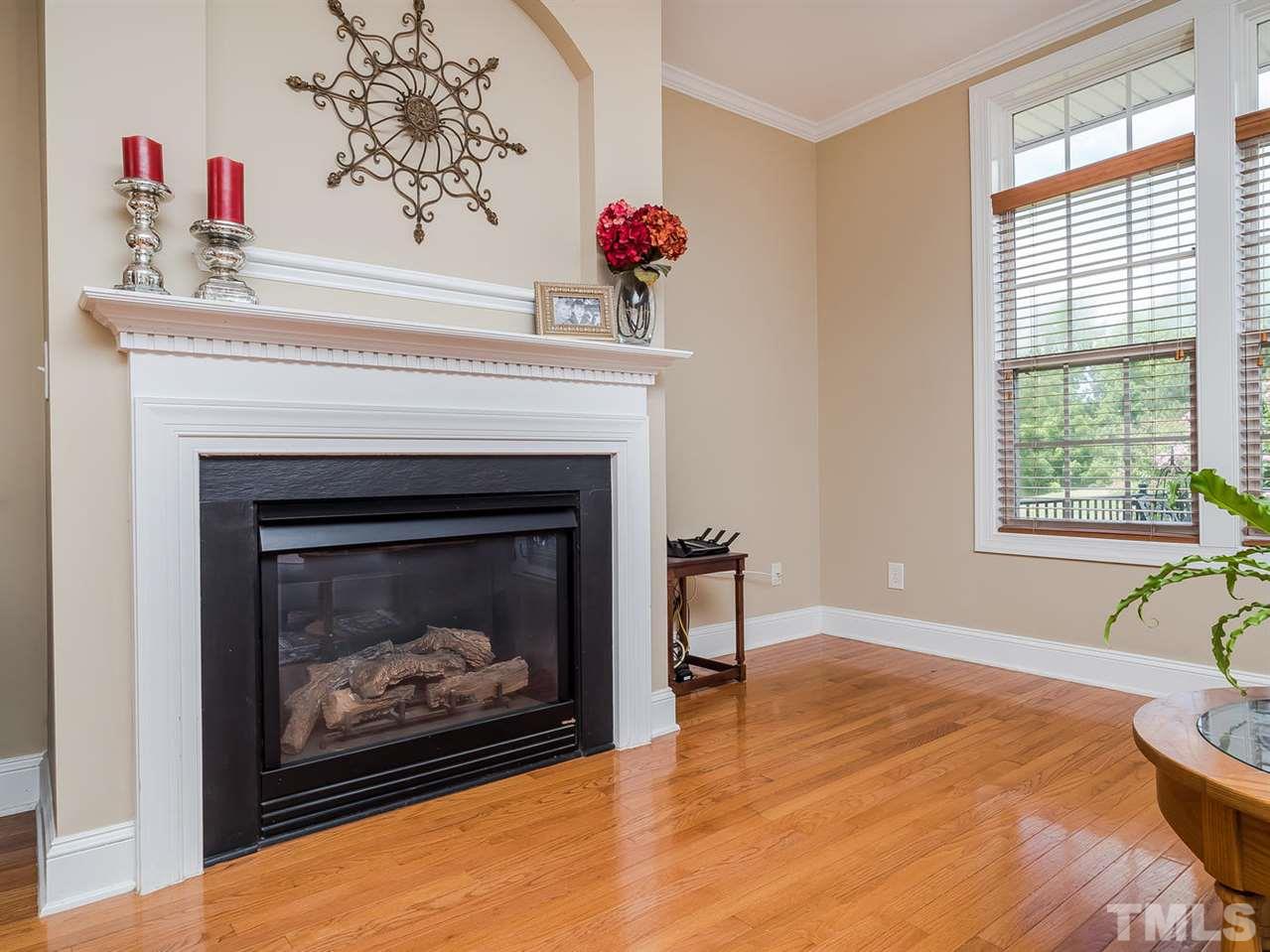 3005 Imperial Oaks Drive Raleigh, NC 27614 - Photo 11 of 25 a living room with a fireplace and wooden floor