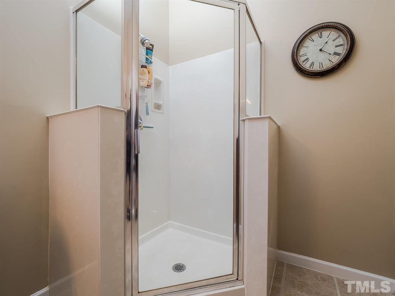 3005 Imperial Oaks Drive Raleigh, NC 27614 - Photo 17 of 25 a bathroom with a shower and a wall clock