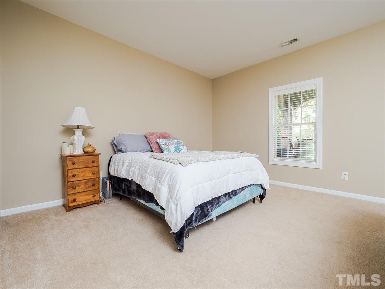 3005 Imperial Oaks Drive Raleigh, NC 27614 - Photo 18 of 25 a bedroom with a bed and a lamp on table