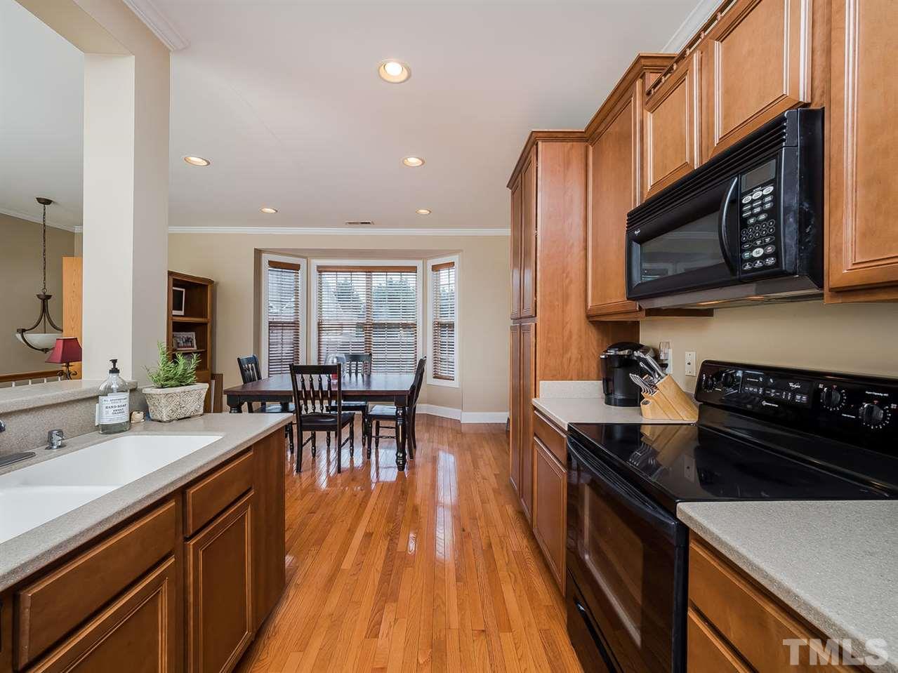 3005 Imperial Oaks Drive Raleigh, NC 27614 - Photo 7 of 25 a kitchen with granite countertop a stove top oven a sink a dining table and chairs