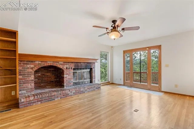 a view of a livingroom with a fireplace and wooden floor