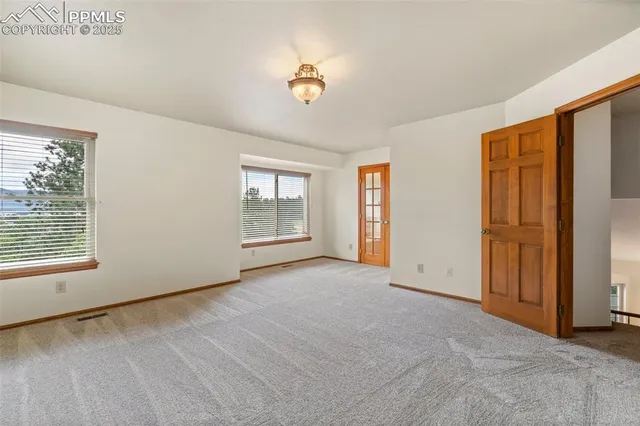 an empty room with windows and closet