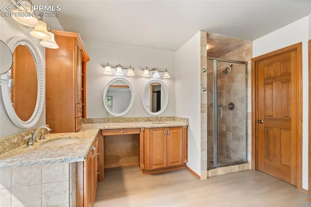 a bathroom with a granite countertop double vanity sink and a mirror
