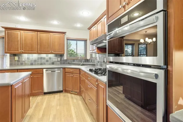 a kitchen with stainless steel appliances granite countertop a stove a sink and a microwave