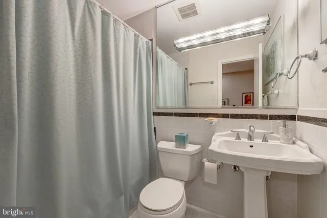 a bathroom with a sink a toilet and mirror
