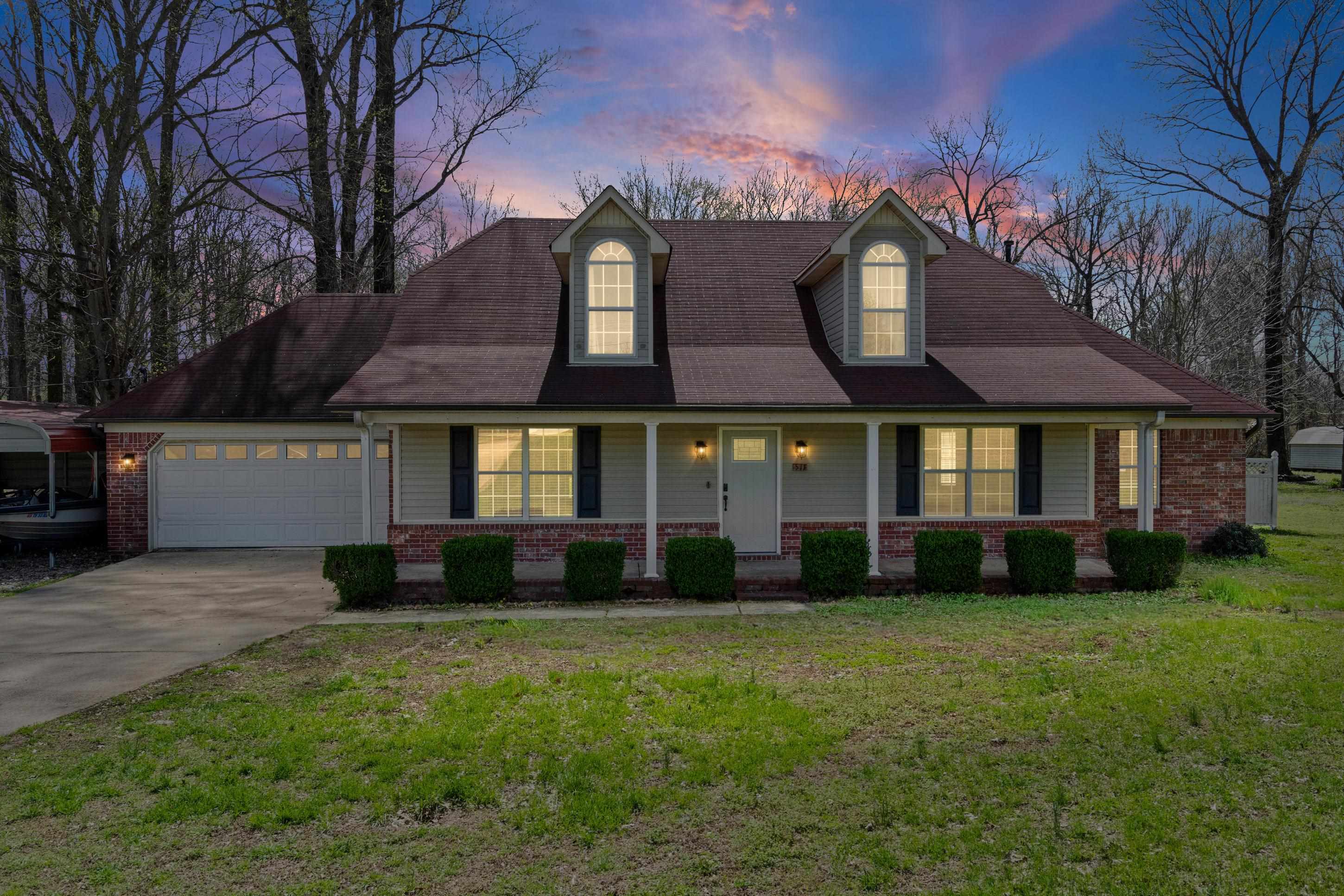 511 Rae Drive Munford, TN 38058 - Photo 2 of 30 Home with covered porch, driveway, an attached garage, a lawn, and brick siding