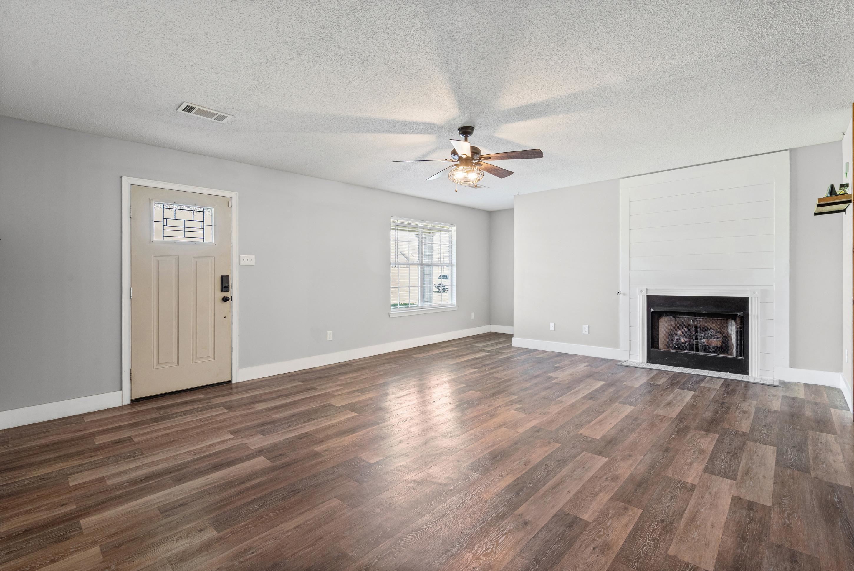 511 Rae Drive Munford, TN 38058 - Photo 5 of 30 Spacious living room featuring a textured ceiling, ceiling fan, dark wood-style flooring, and a large fireplace