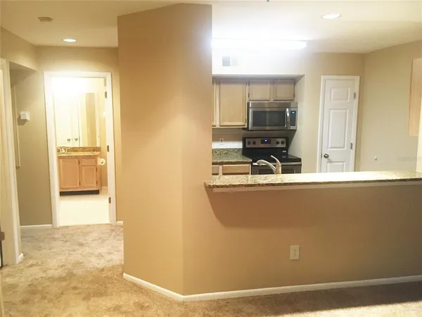 a kitchen with granite countertop a refrigerator and a sink