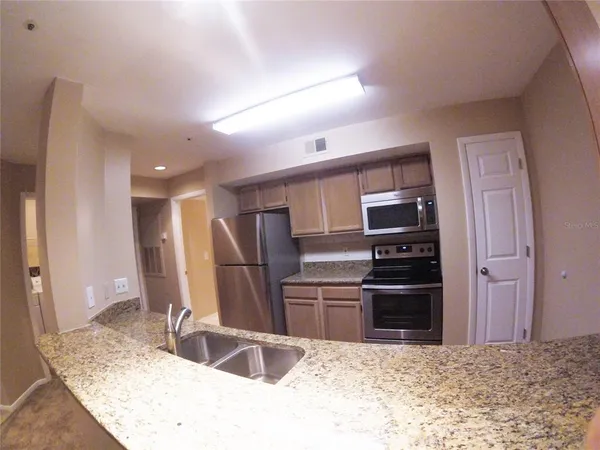 a kitchen with granite countertop a sink and stainless steel appliances