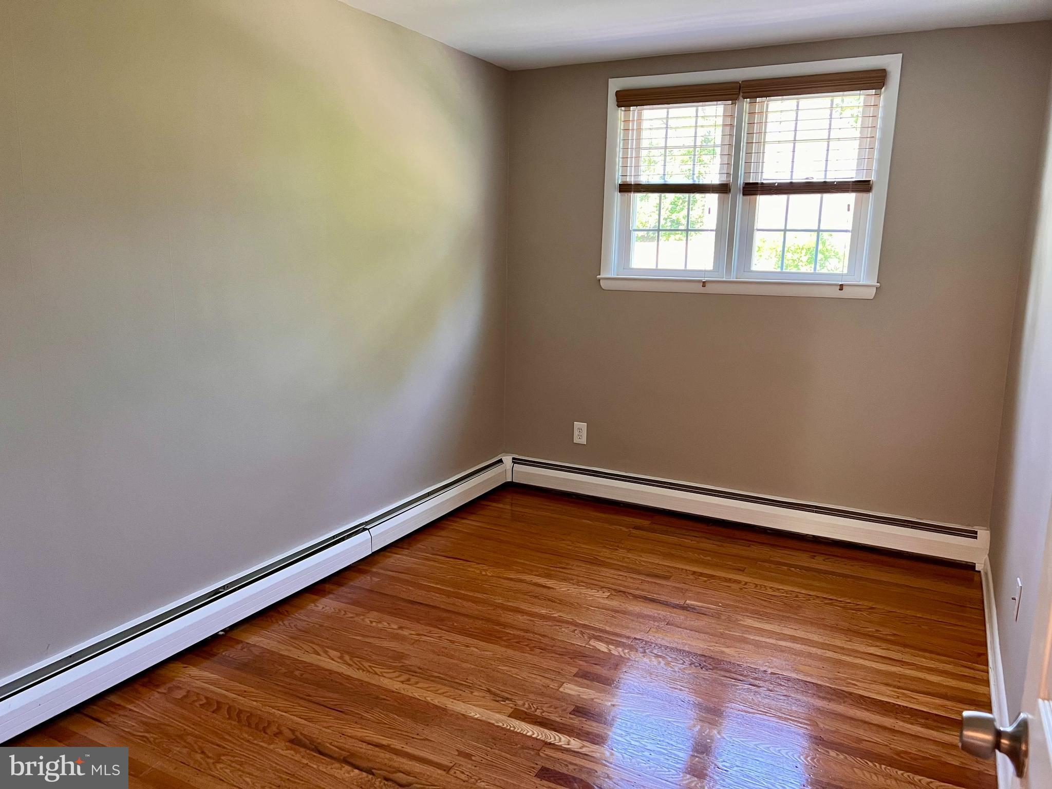 7804 Winston Road, Unit 1 Philadelphia, PA 19118 - Photo 12 of 13 an empty room with wooden floor and windows