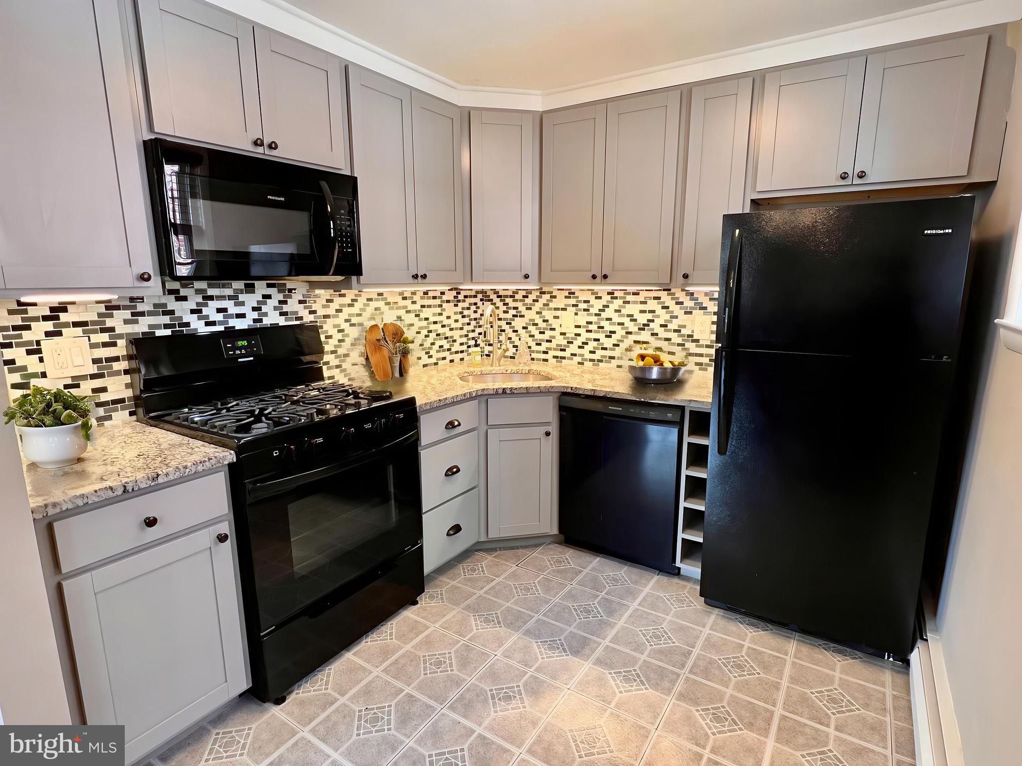 7804 Winston Road, Unit 1 Philadelphia, PA 19118 - Photo 6 of 13 a kitchen with granite countertop a refrigerator stove and microwave