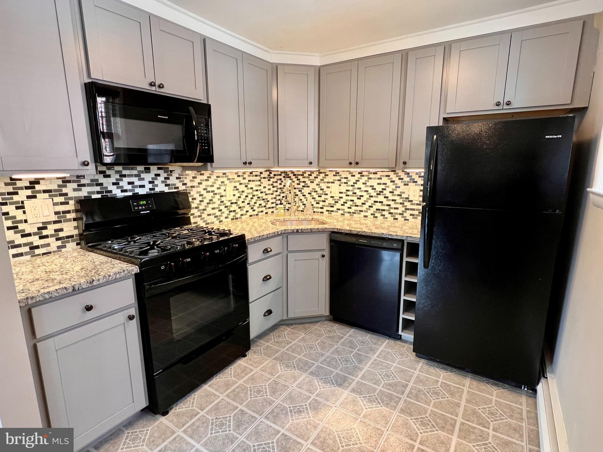 7804 Winston Road, Unit 1 Philadelphia, PA 19118 - Photo 7 of 13 a kitchen with granite countertop a refrigerator stove and microwave