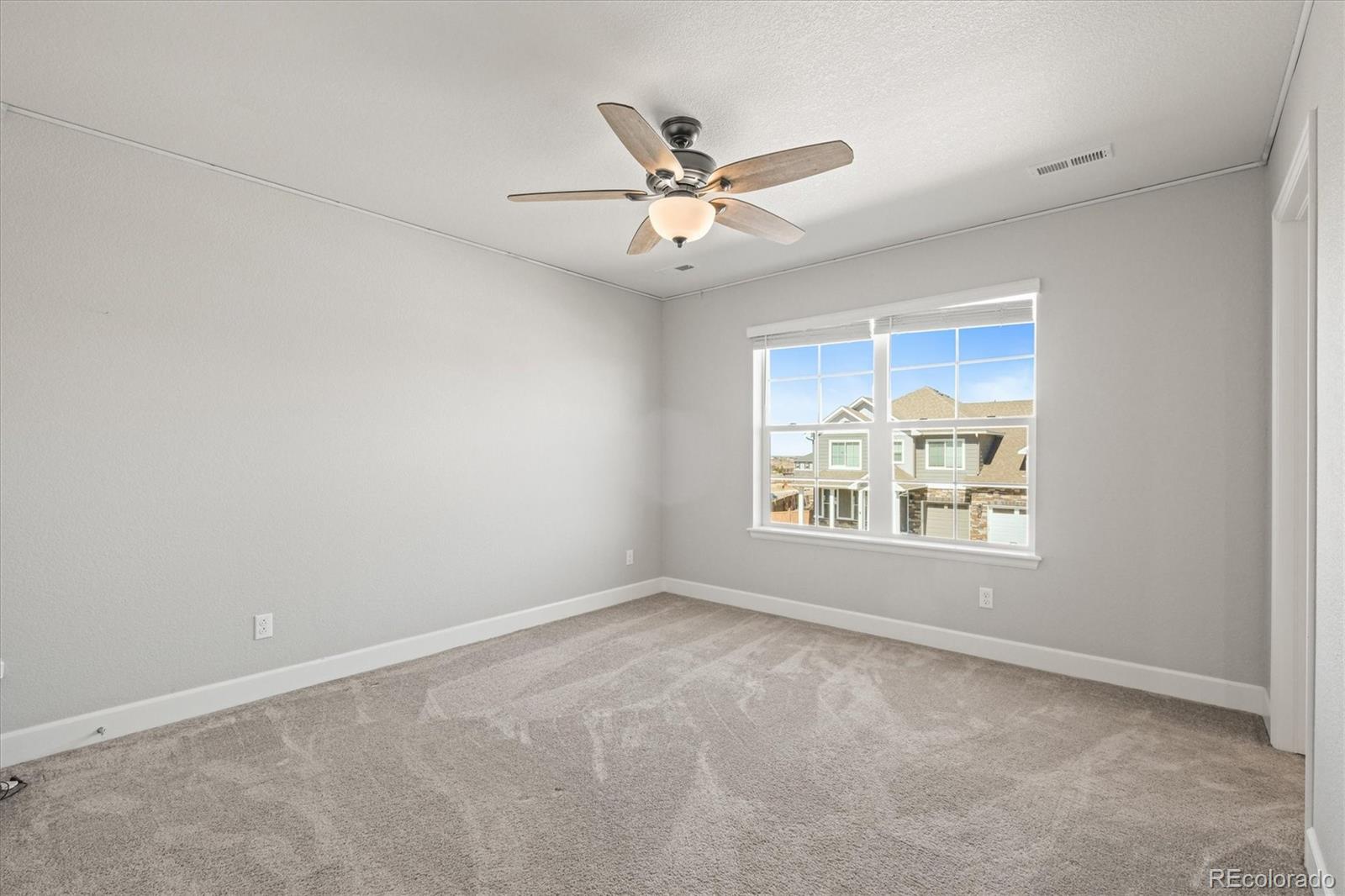 1624 Pinion Wing Circle Castle Rock, CO 80108 - Photo 30 of 47 an empty room with windows and ceiling fan