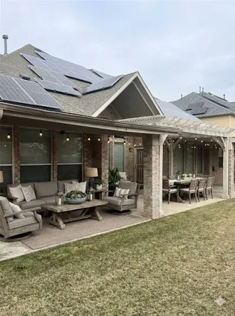 a view of a patio with table and chairs near a barbeque