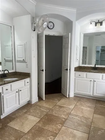 a spacious bathroom with a mirror sink and cabinets
