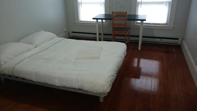 a bed sitting in a bedroom next to a window